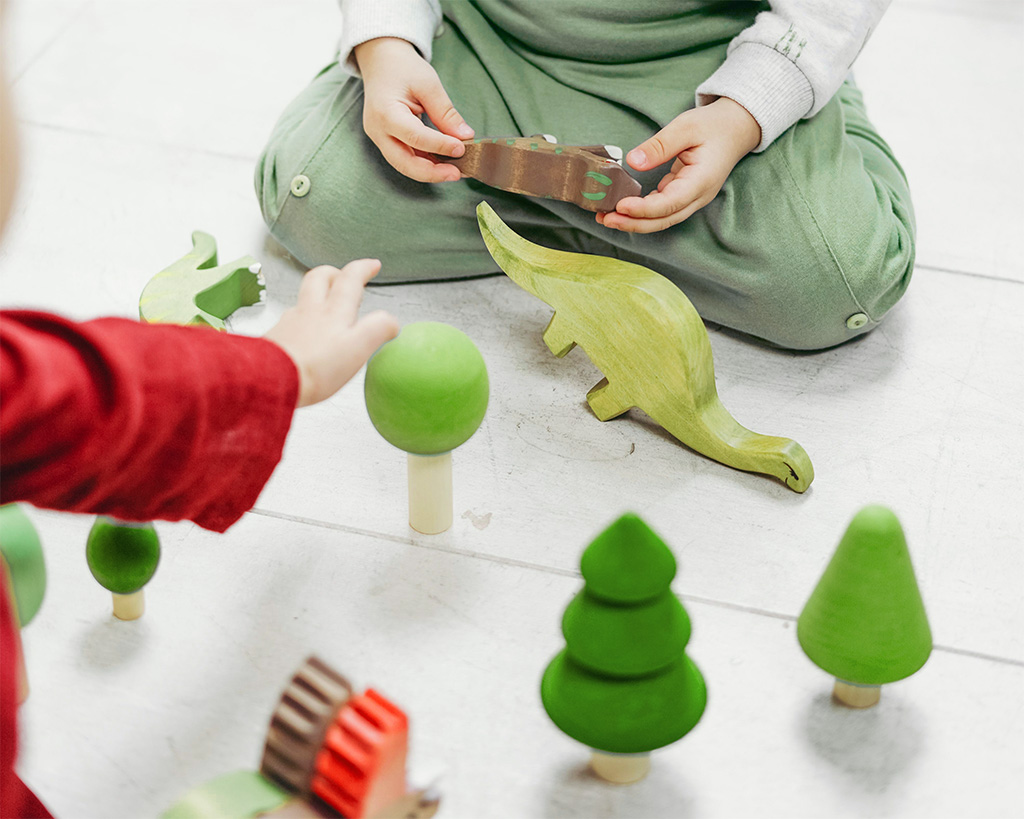 Niño jugando con un dinosaurio durante una sesión de psicología infantil
